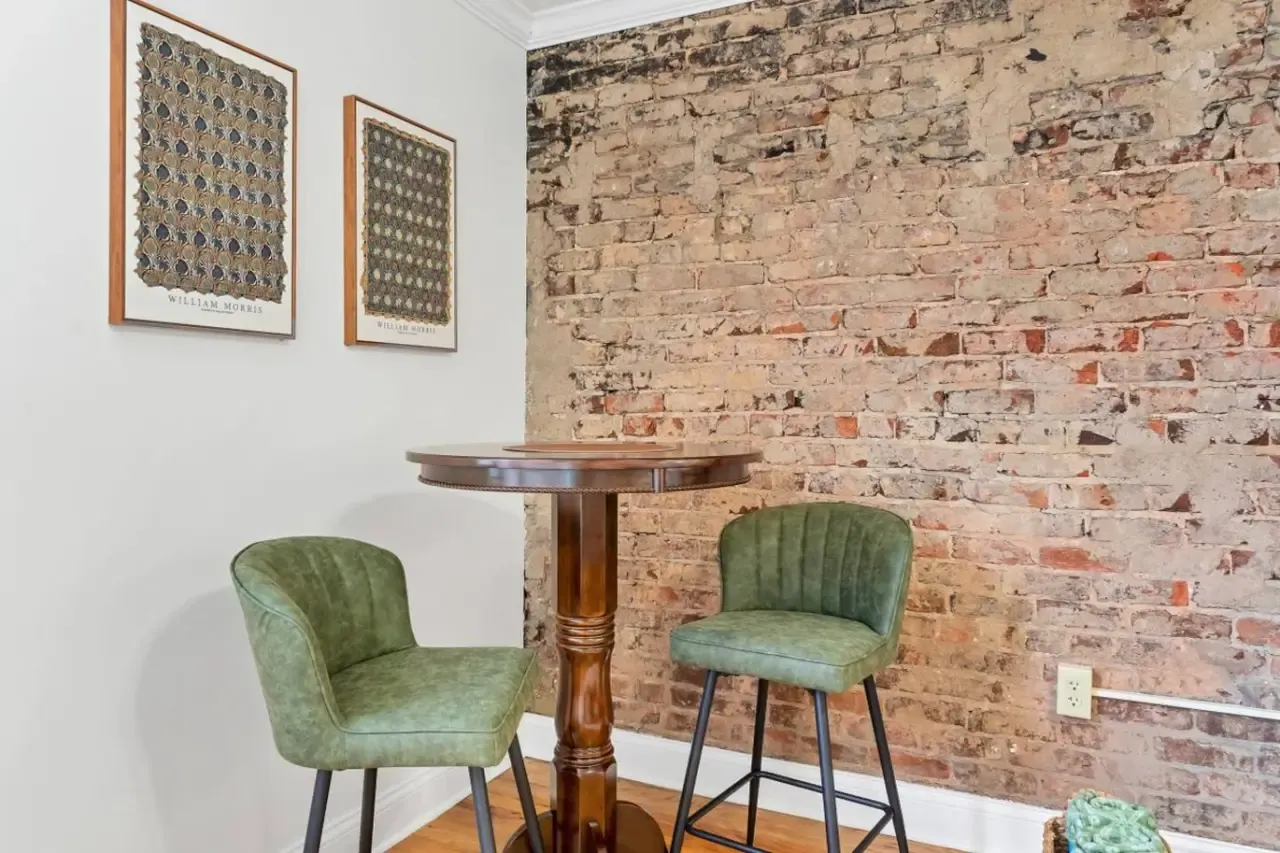 Dining table and exposed-brick wall in Perch Over Pistol Creek